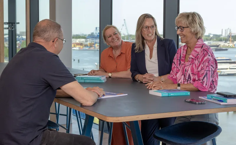 drie cursisten van STC next met docent aan tafel tijdens cursus op de Waalhaven Zuidzijde 16