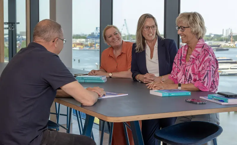 drie cursisten van STC next met docent aan tafel tijdens cursus op de Waalhaven Zuidzijde 16