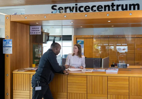 man stelt vraag aan medewerker bij servicecenter van STC