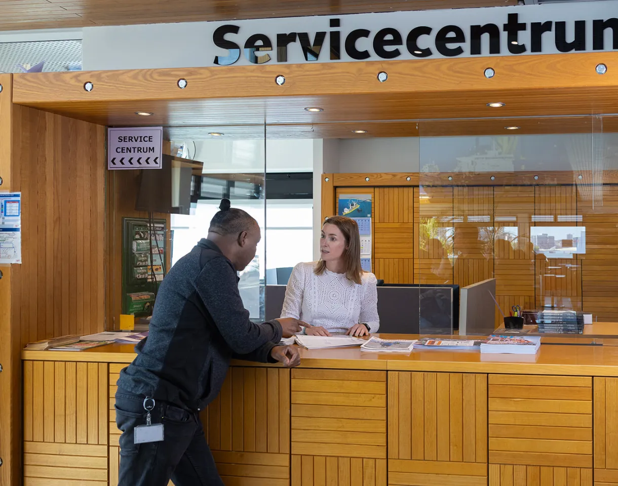 man stelt vraag aan medewerker bij servicecenter van STC
