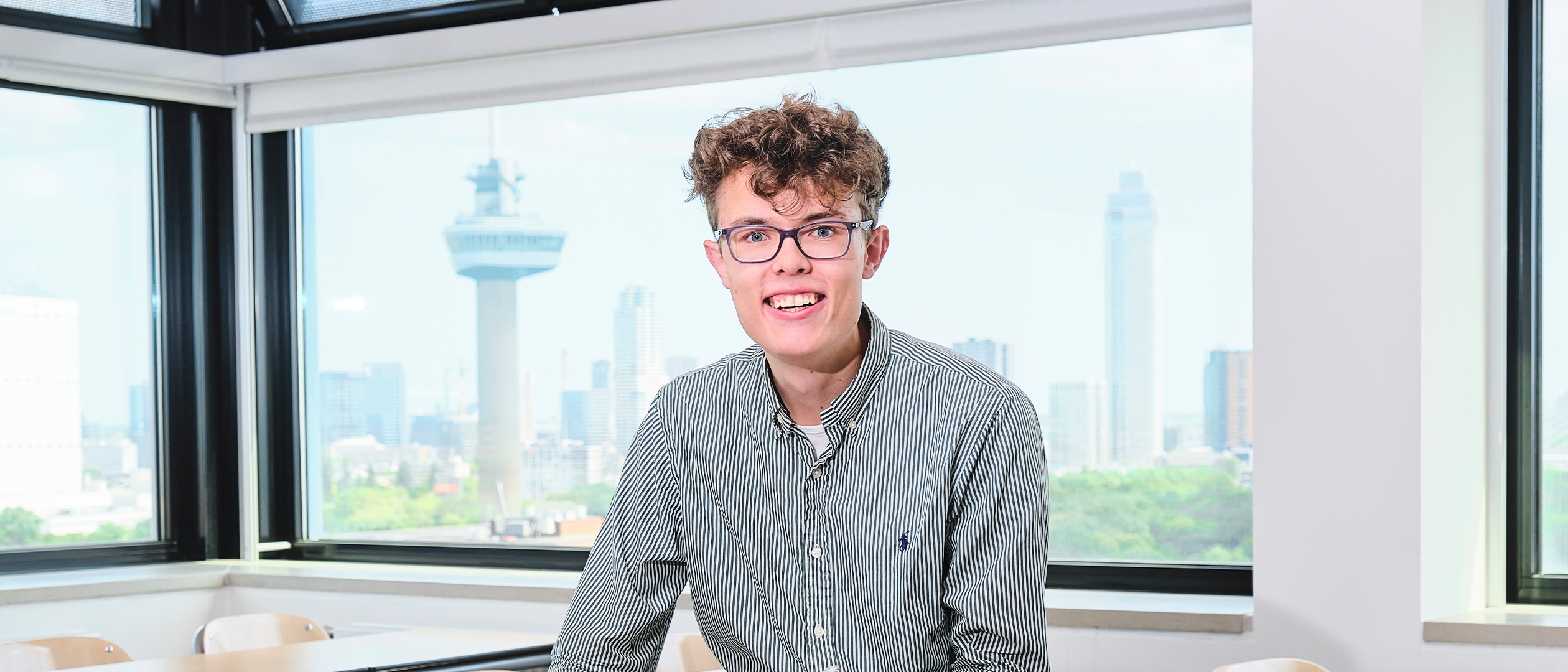 student in klasruimte met uitzicht op Euromast
